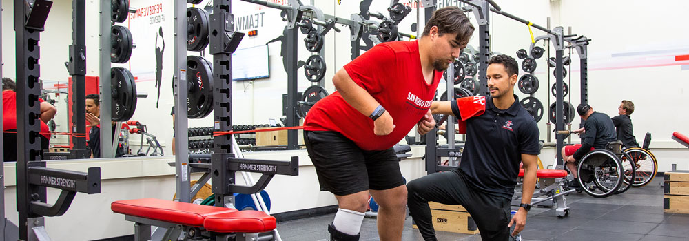 Adapted Athletics team member working out at Performance Center with coach