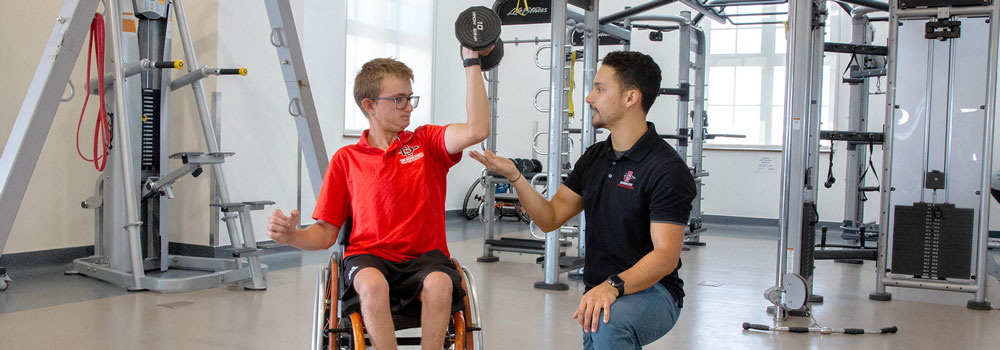 Adapted Athletics team member working out at ARC Express with coach