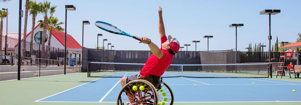 Wheelchair tennis player serving at Aztec Tennis Courts