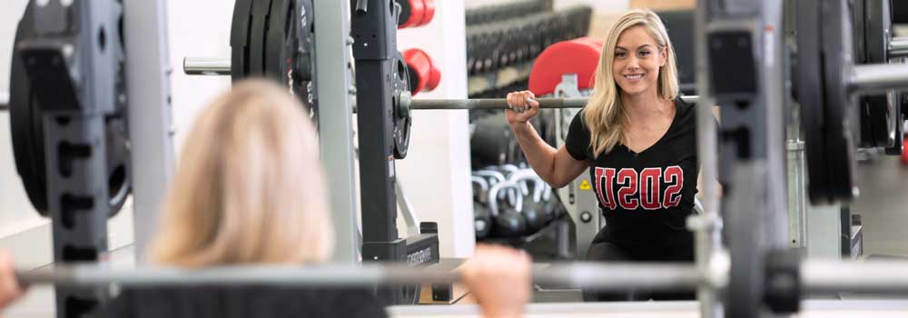 Woman performing a squat using Smith Machine