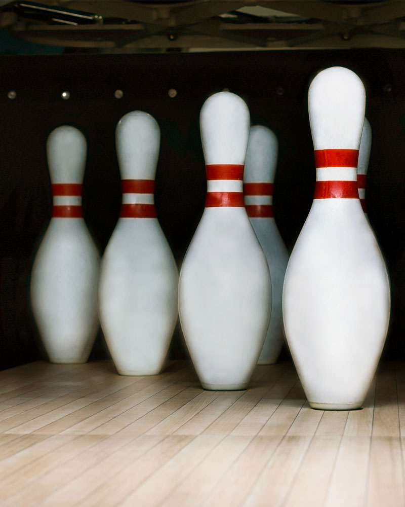 Four smiling friends holding bowling balls