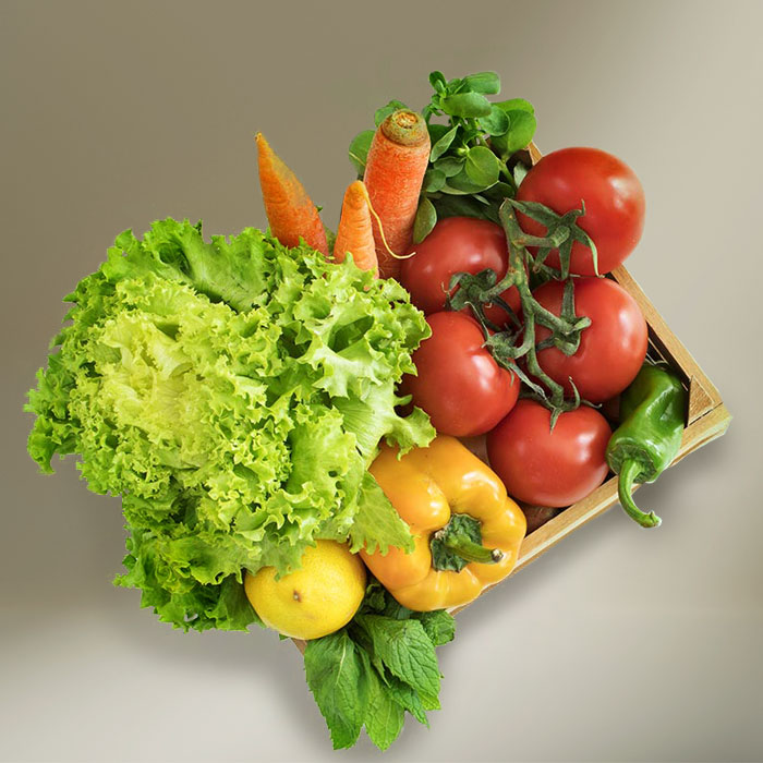 Wooden box filled with a variety of fresh vegetables