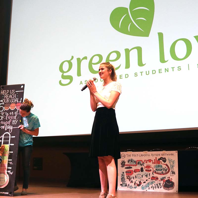 Female speaker on stage at a GreenLunch Bag event