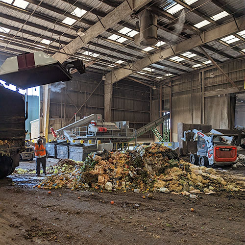 EDCO employees working to turn compostable waste into soil.