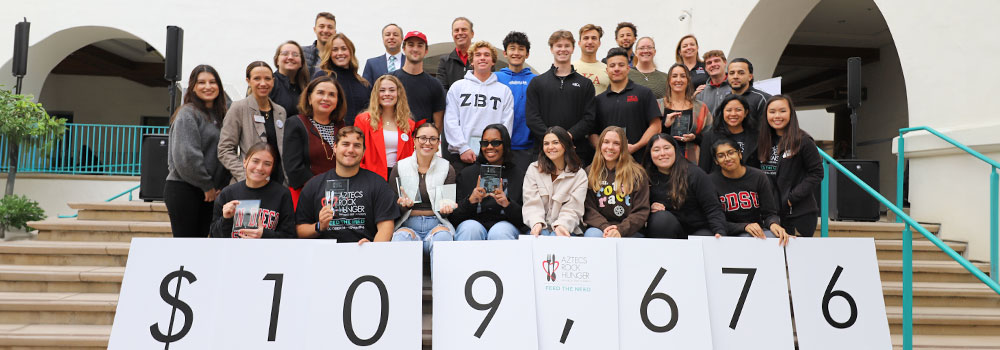 Group of people at Aztecs Rock Hunger donation reveal $109,676 raised