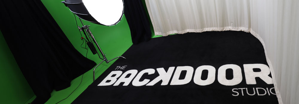 Inside Backdoor Studio: greenscreen, box light and rug with backdoor studio logo