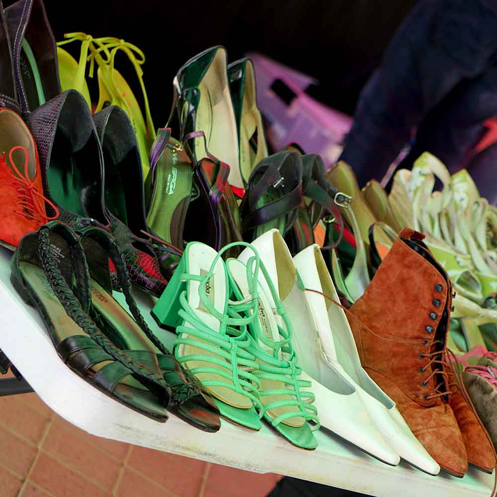 Many used shoes shown on a display table - wide variety of styles and colors