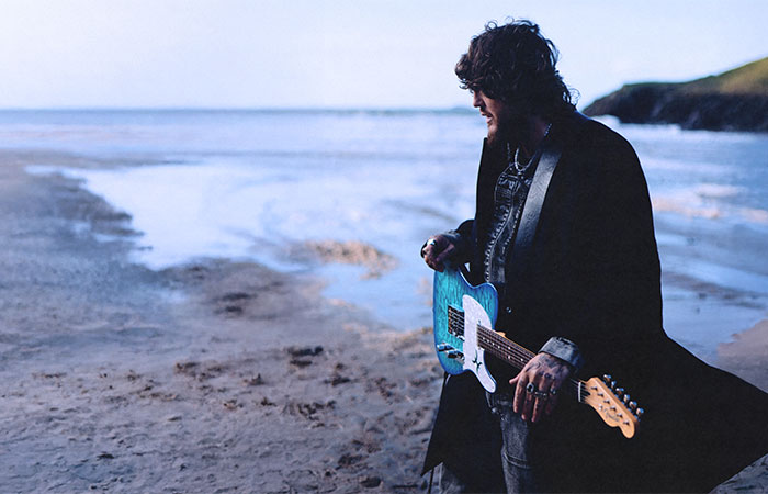 James Arthur at the beach with a guitar Photo