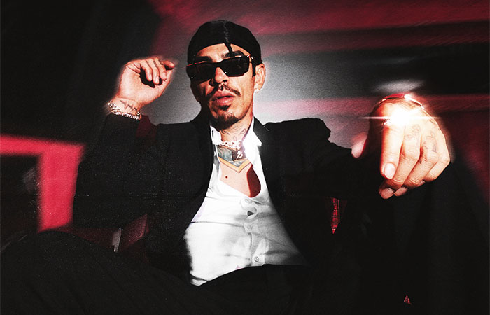 Codiciado sitting in a suit with sunglasses Photo