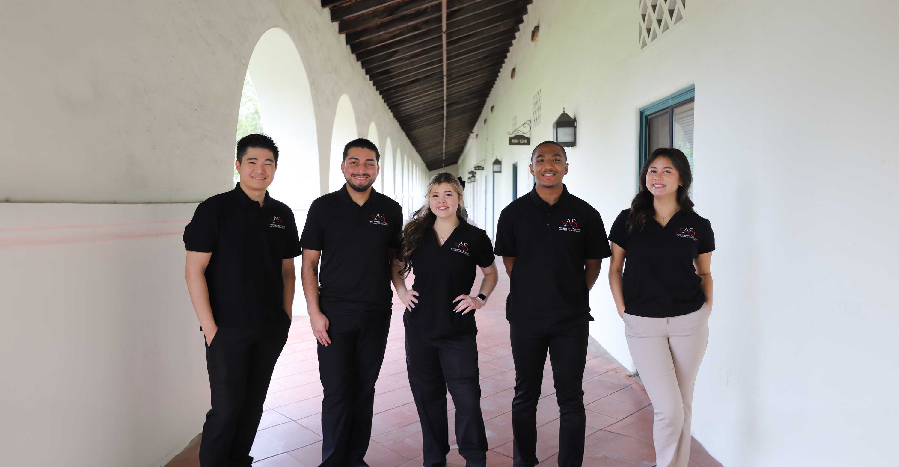 Six smiling SDSU students sitting on the stairs of the Student Union