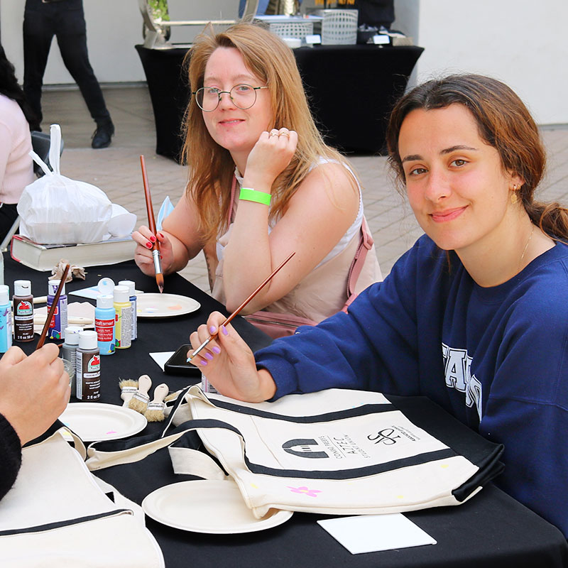 Students painting reusable bags at a ars and crafs ASUB event
