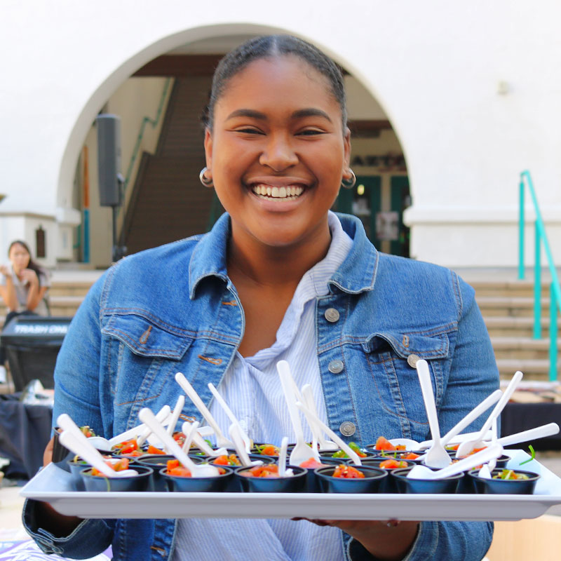 Student holding a tray of food samples