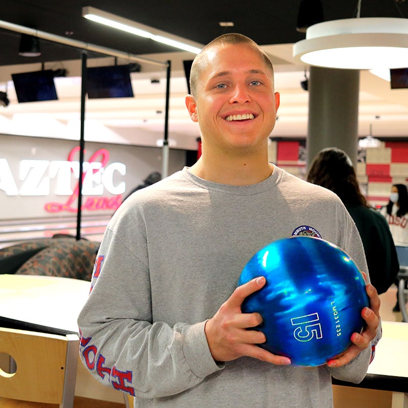 Student holding bowling ball in Aztec Lanes - ASUB Event