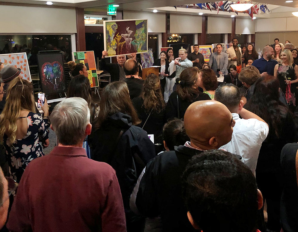 Crowd of people bidding on a painting