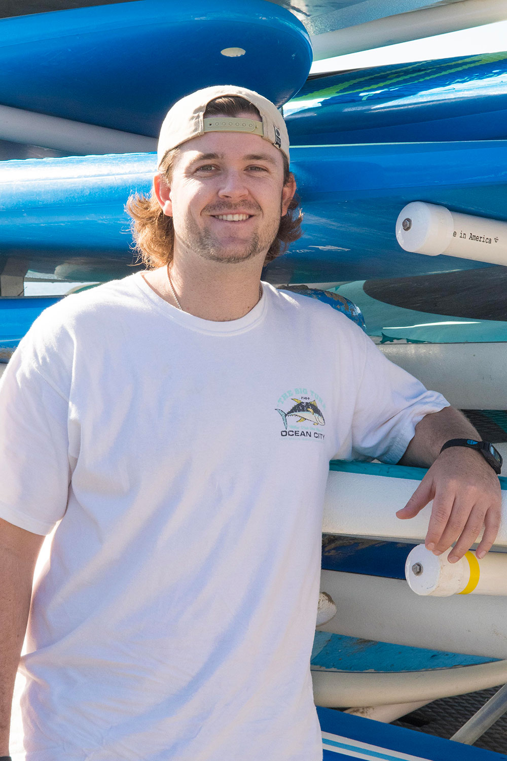 Travis Lamke with a background of paddle boards