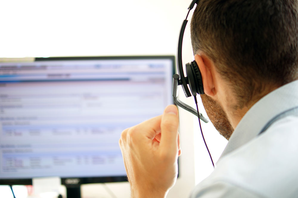 View from behind of a customer service rep working on a computer?2024-04-23