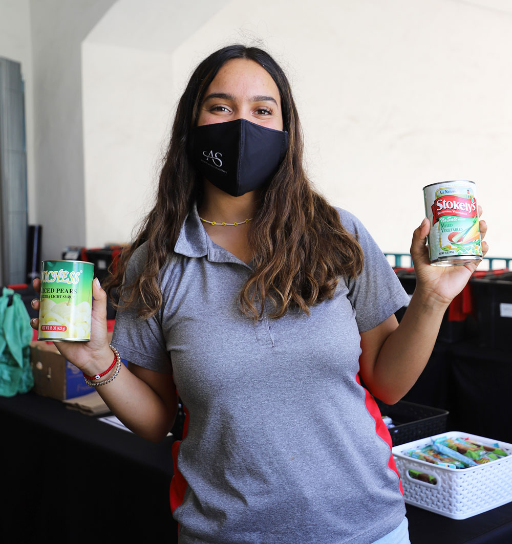 Student holding cans of food