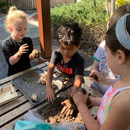 Group of children making mud pies