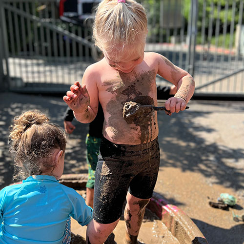 Child pouring mud on themself