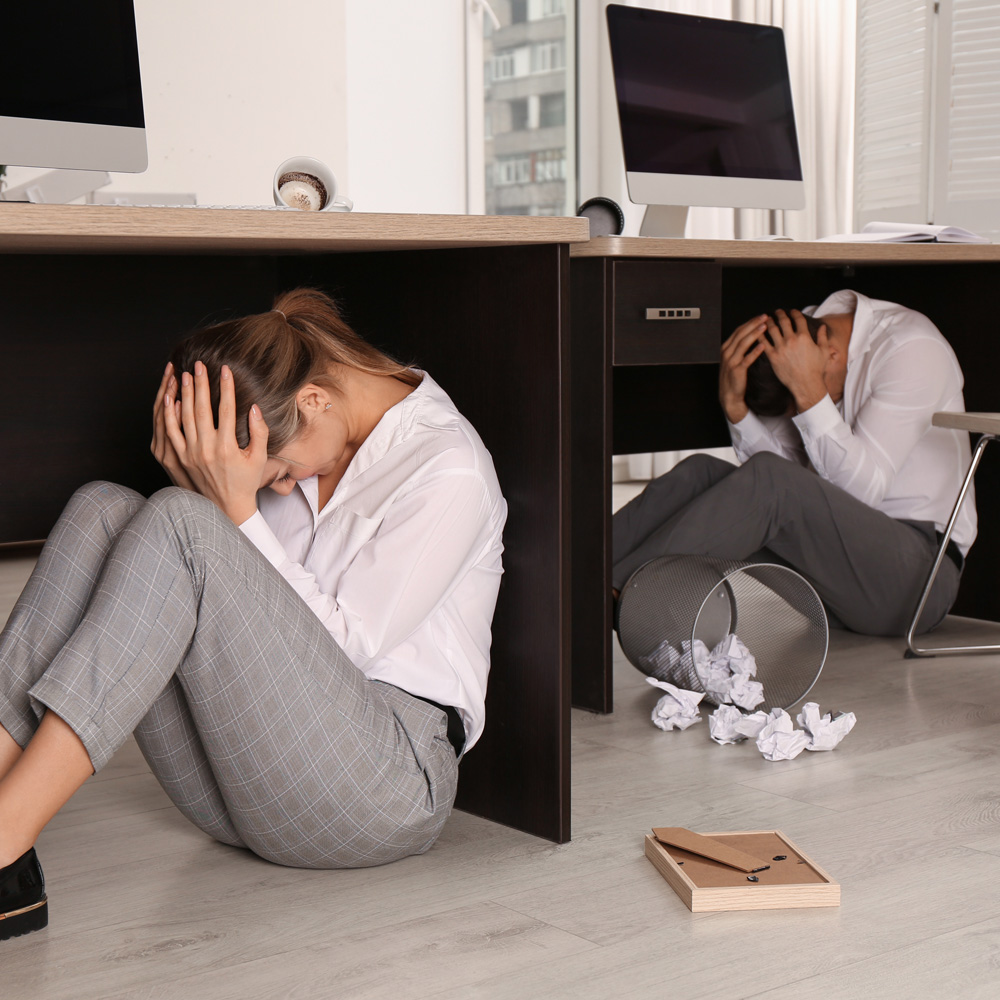 Two individuals seeking cover during an earthquake.