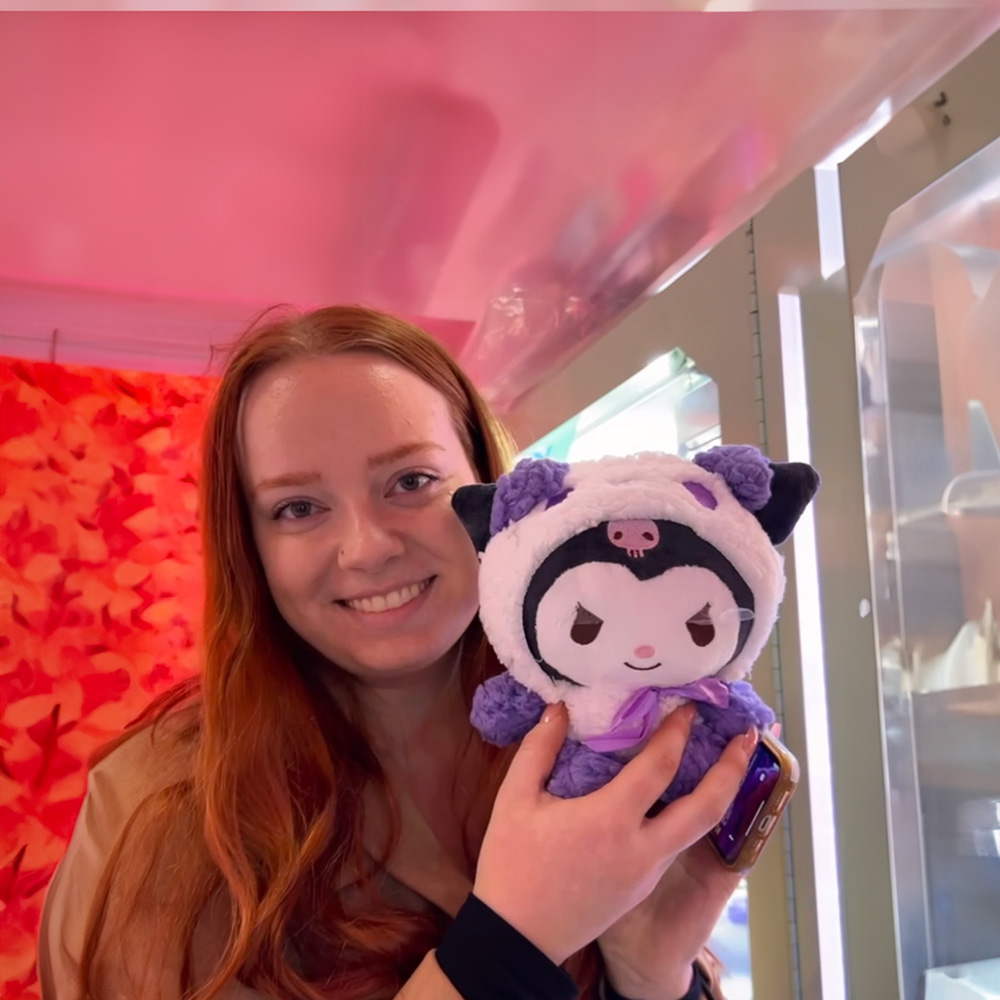 Caitlyn McFadden on a bus holding a plushie.