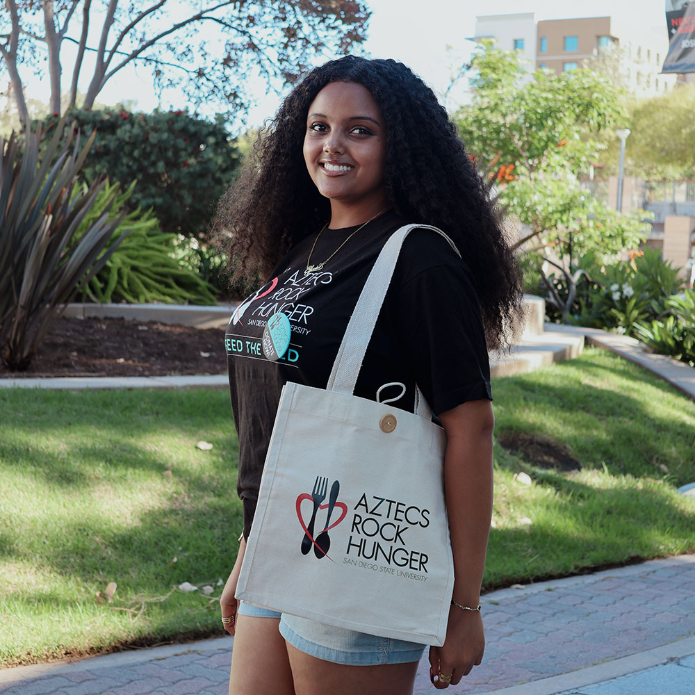 A member of Aztecs Rocks Hunger using an ARH bag.