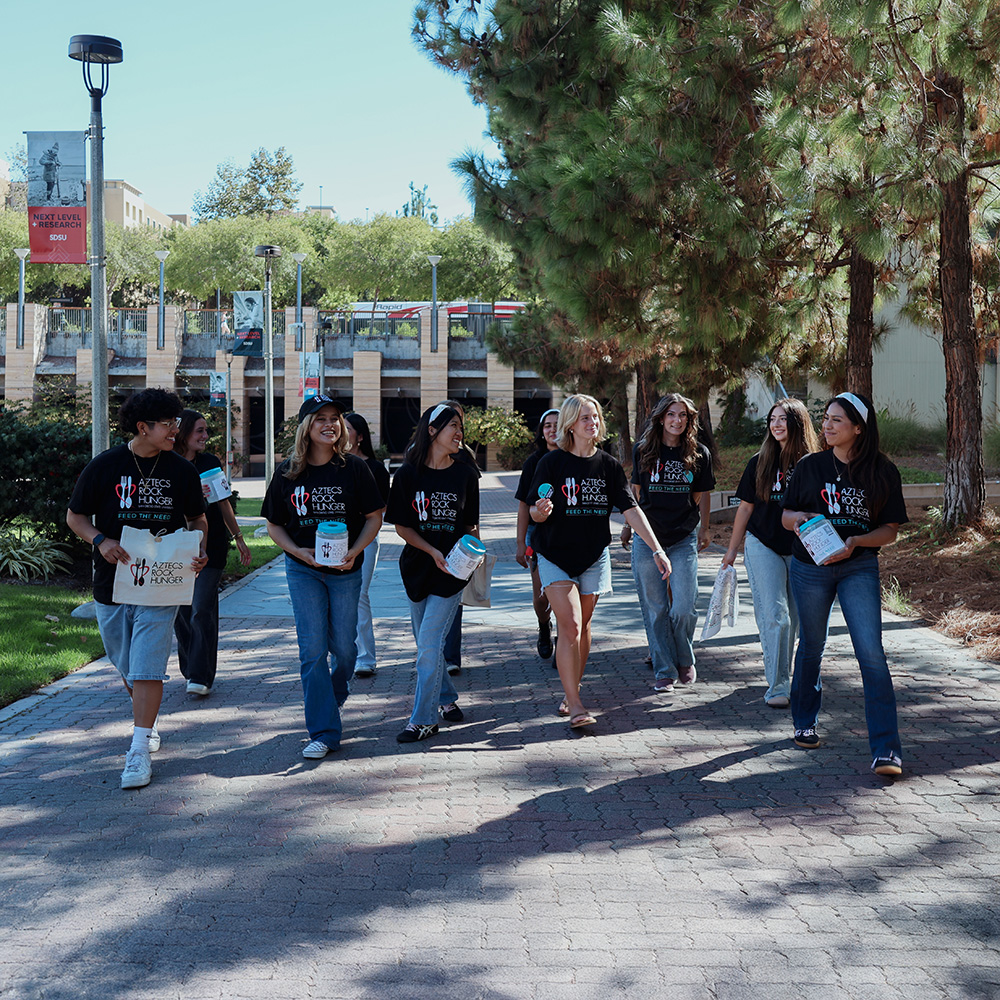 Members of Aztecs Rocks Hunger walking a path together.