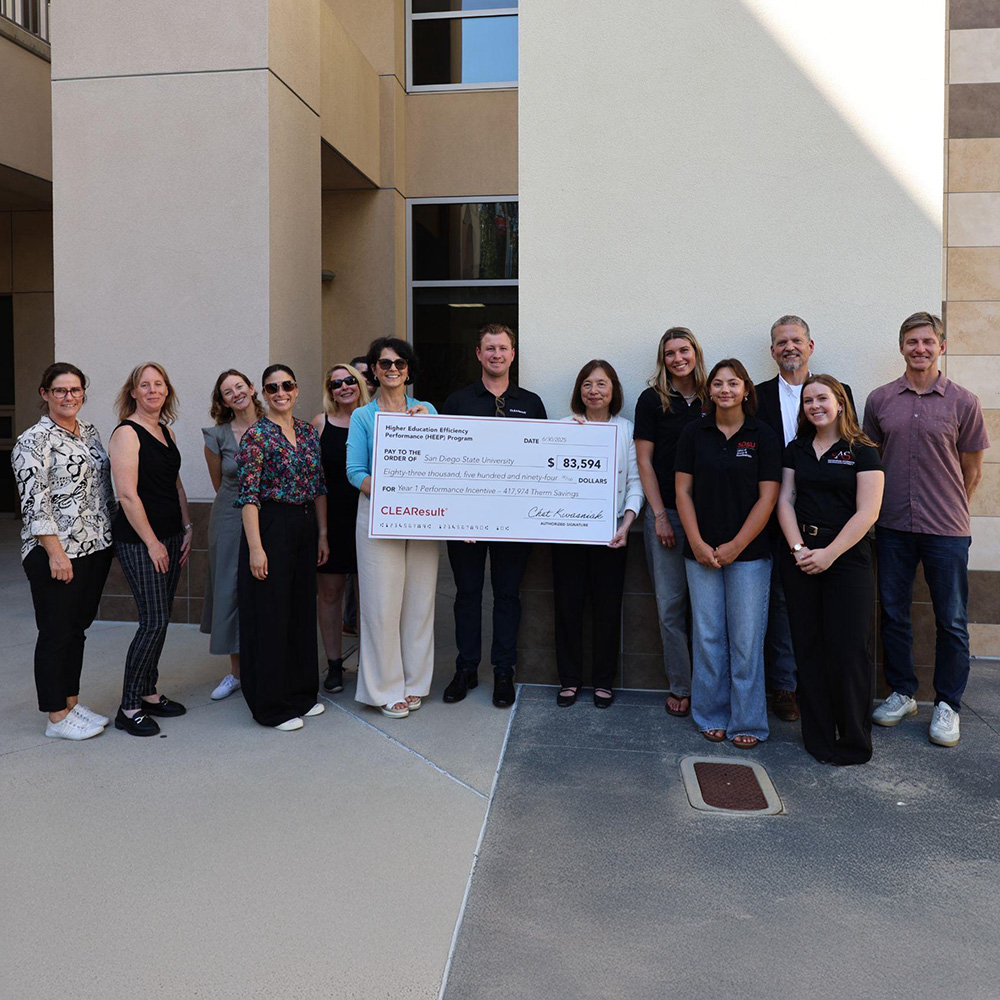 Staff members holding a giant check.