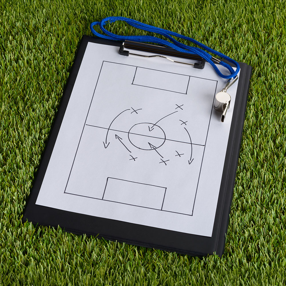 A clipboard with a soccer tactic diagram.