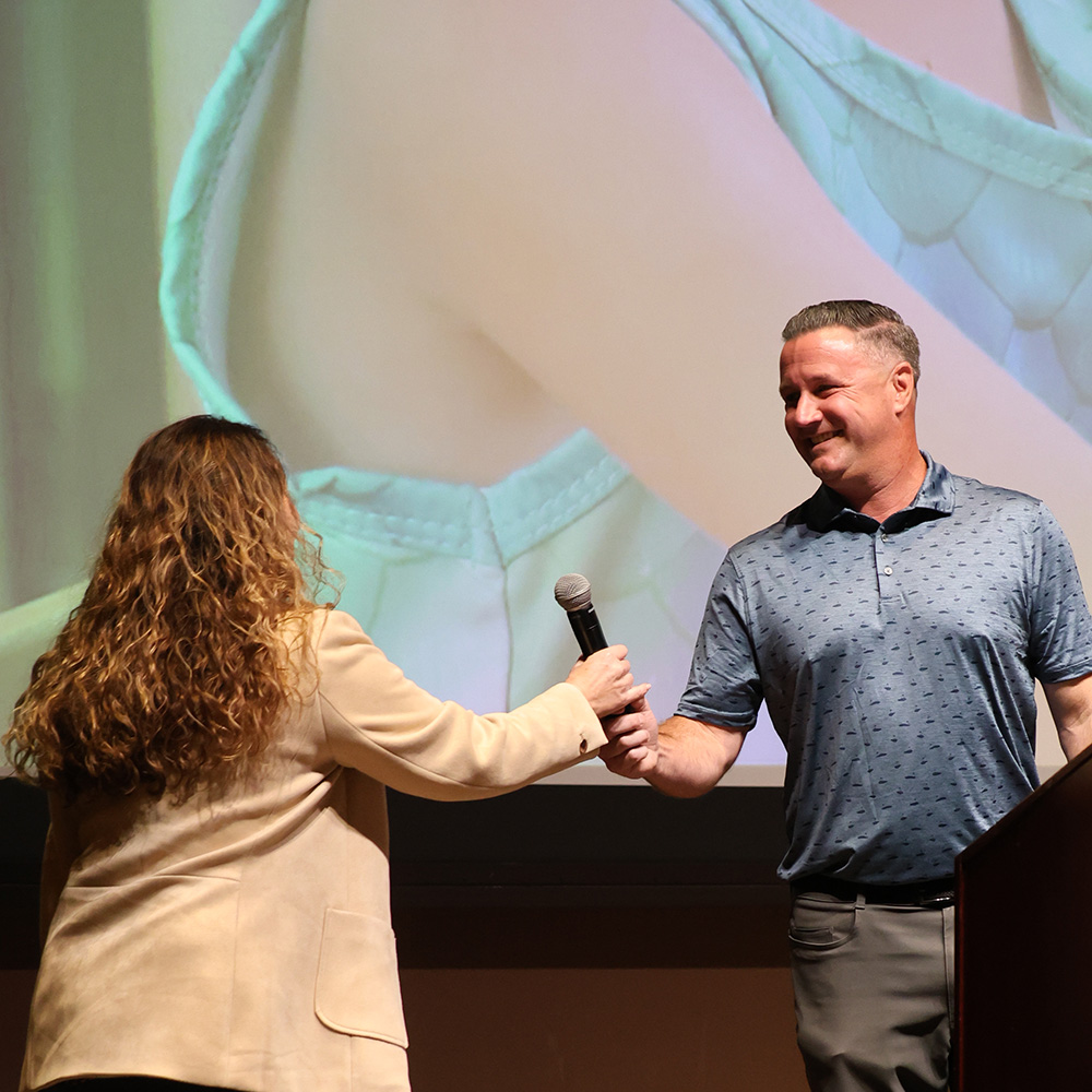 Ryan Delong hands off the microphone to Patty Rea.