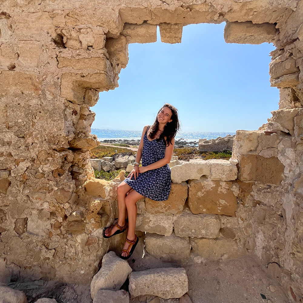 Brielle sitting in a ruined wall.