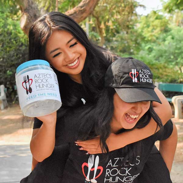 Two laughing ARH members with a donation jar