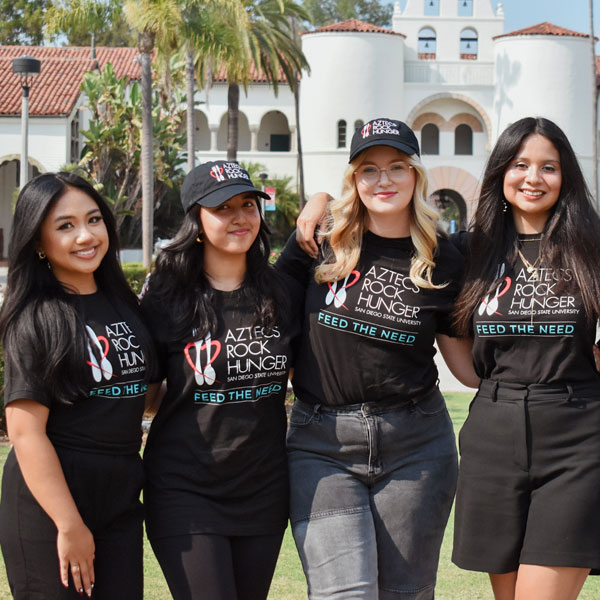 Four smiling ARH members in front of the Hepner Hall