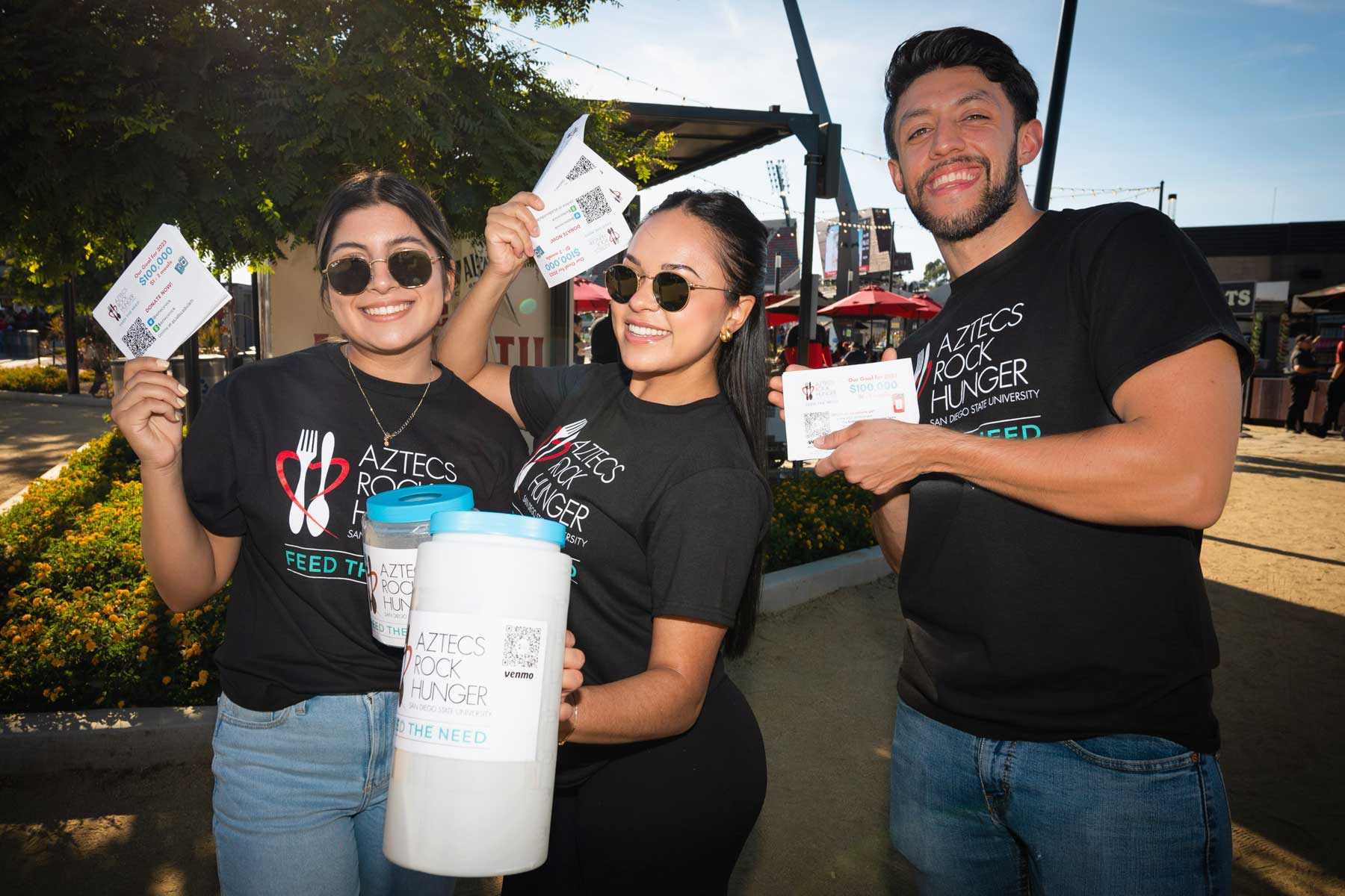 Three women holding ARH donation jars in front of Hepner Hall