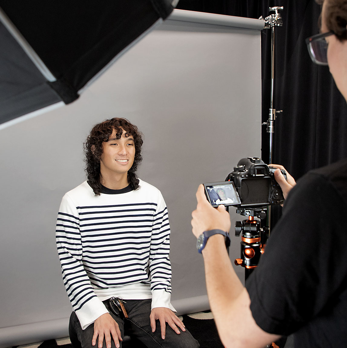 Headshot photoshoot in progress. Woman posing in front of a photographer